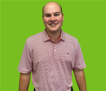 Male employee on green background with red shirt